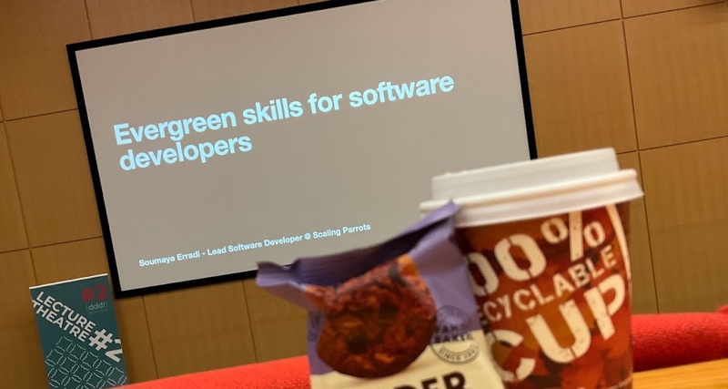 a coffee cup and a cookie in front of a projector screen showing the session title