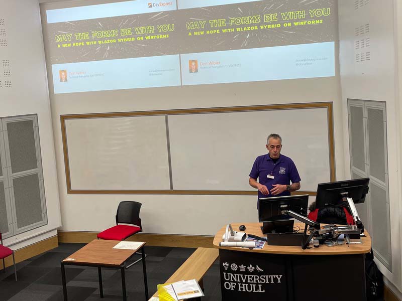 Don Wibier giving a talk in front of projector screens